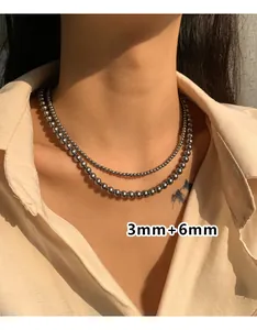 Detail van 3mm en 6mm gepolijste zilveren kralenkettingen in lagen op het model