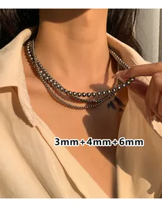 Drielaagse metalen kralenketting met 3mm, 4mm en 6mm kralen gedragen door een model