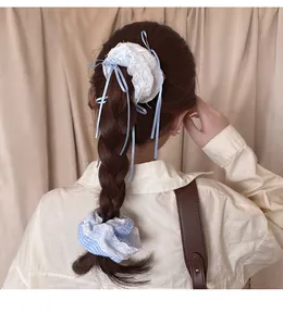 Detail of sweet lace scrunchies with ribbons on a braided hairstyle for girls