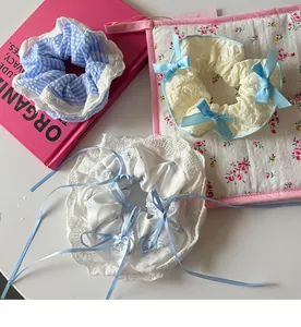 Close-up of three lace scrunchies with ribbons and bows on a floral quilted mat