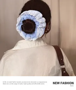 Detail of a blue and white checkered scrunchie with lace trim on a bun hairstyle