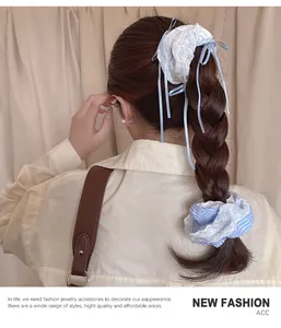 Detail of sweet lace scrunchie with long ribbon bow on braided hair styling