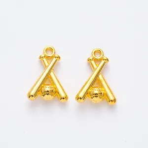 Macro shot of two vintage golden baseball and bat alloy charms for DIY jewelry making