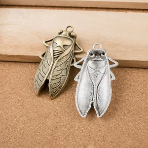 Makroaufnahme von Vintage-Zikadenanhängern in Antik-Bronze und Antik-Silber