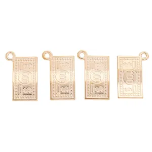 Detailed view of gold dollar sign charms for DIY jewelry with fine engraved textures
