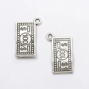 Detail of vintage silver alloy 100 dollar bill charms with embossed texture for DIY jewelry