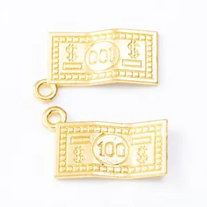 Macro view of double gold-plated alloy pendants shaped like $100 bills for DIY jewelry