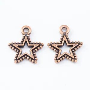 Macro detail of two vintage bronze star pendants with hollow centers and beaded edges