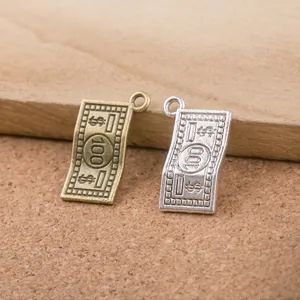 Detailed macro view of bronze and silver dollar bill charms for DIY jewelry making