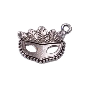 Détail du pendentif masque argenté vintage avec motifs plumes et bordure perlée