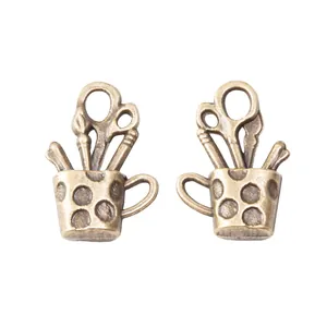 Vintage bronzen DIY beker hanger met schaar en penselen op een witte achtergrond