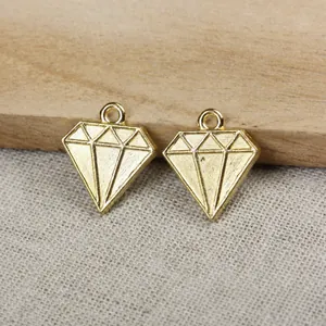 Vue détaillée de deux pendentifs dorés en forme de diamant sur tissu de jute