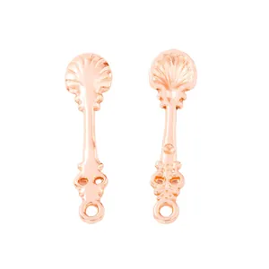 Detailed view of rose gold shell texture charms and filigree jewelry connectors