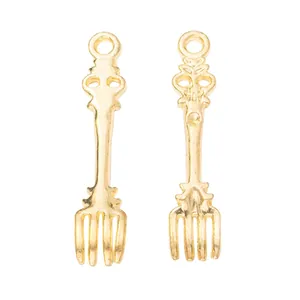 Macro detail of pair of vintage gold-plated zinc alloy fork pendants for DIY jewelry making
