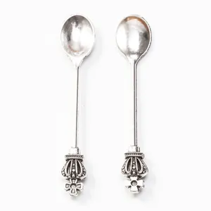 Détail de deux cuillères couronne en argent vintage avec des gravures royales en croix