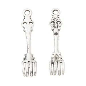 Macro view of vintage silver alloy fork pendants with detailed floral textures and hanging loops