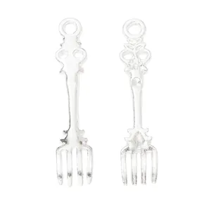 Detail view of vintage silver alloy fork pendants for DIY jewelry making and crafts