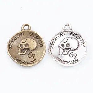 Vintage zinc alloy round skull charms in antique bronze and silver finishes with hanging loops