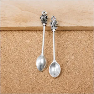 Macro detail of vintage alloy crown spoon pendants with antique silver finish and embossing