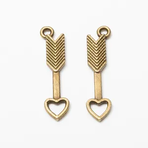 Pair of vintage bronze alloy bow and arrow pendants with heart tips for DIY jewelry making