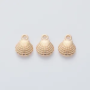 Close-up of three gold shell pendants with radial textures and integrated top loops