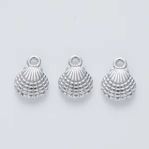 Detailed view of three silver scallop shell metal pendants with refined radial texture
