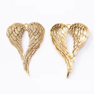 Détail de pendentifs ailes d'ange dorées montrant la texture recto et la structure verso