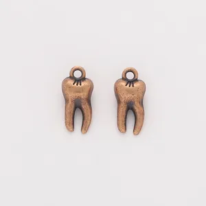 Detailed close-up of antique bronze tooth charms with vintage alloy textures for DIY jewelry