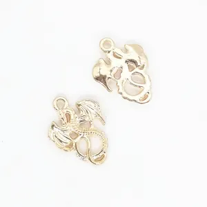 Pair of detailed gold dragon alloy pendants for DIY jewelry making on white background