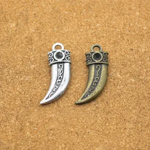 Dettaglio macro di ciondoli vintage a forma di corno con dimensioni di 22x9x4mm