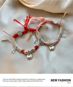 Detail van handgeweven armbanden met gelukshangers op zijden achtergrond