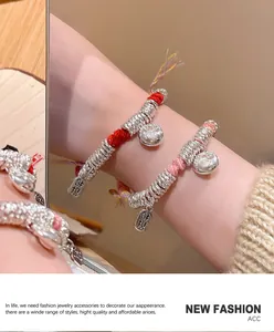 Detail van handgeweven touwarmbanden met geluksbedeltjes en traditionele kwastjes