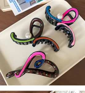 Detail of colorful irregular resin hair claws with contrast glaze and pearl accents