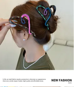 Detail view of heart-shaped hair claw clip with colorful abstract patterns on hair