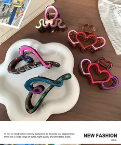 Detail showing irregular colorful heart-shaped hair claw clips on a white petal tray