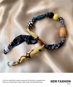 Dettaglio della collana foulard in seta leopardata con perle e trame in tessuto retrò