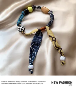 Dettaglio della collana foulard leopardata con perle in tessuto fatte a mano e inserti in legno