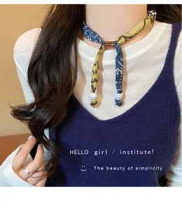 Dettaglio della collana vintage in tessuto leopardato con perla marmorizzata e fiocco