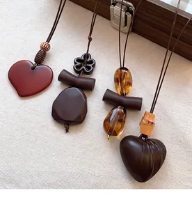 Detail showing assorted hollow geometric heart pendants and wood textures on linen fabric