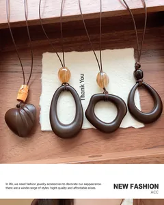 Macro view of four retro geometric resin pendants including heart and oval shapes