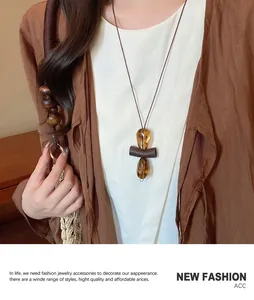 Detail of amber water滴 beads on a long ethnic style necklace worn by a model