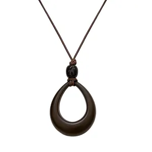 Vintage hollow teardrop pendant necklace with brown cord for a minimalist retro look