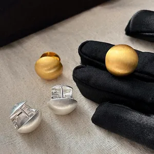 Pendientes de bola en oro y plata cepillados con textura metálica de estilo minimalista