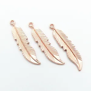 Gedetailleerde weergave van drie roségouden vederhangers voor DIY-sieradenaccessoires