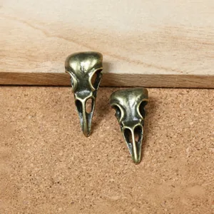 Detailed view of vintage bronze bird skull pendants for DIY jewelry making and crafts