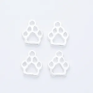 Macro detail of four silver-plated bear paw hollow charms for DIY jewelry making