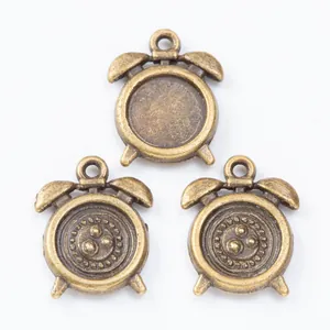 Macro shot of three bronze alarm clock charms showing bezel base and textured back for DIY jewelry