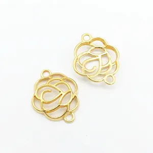 Detail of two golden hollow camellia flower connectors with double loops for DIY jewelry
