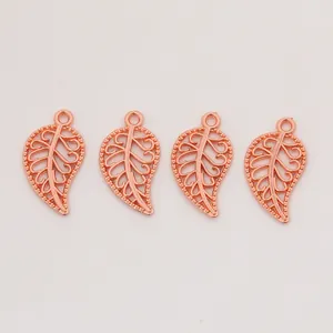 Détail de quatre pendentifs feuilles ajourés en or rose pour la création de bijoux DIY