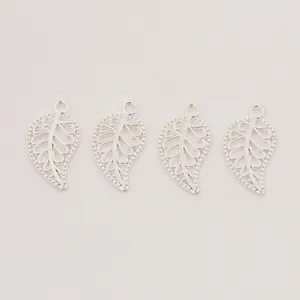 Détail de quatre breloques feuilles argentées évidées pour la création de bijoux DIY
